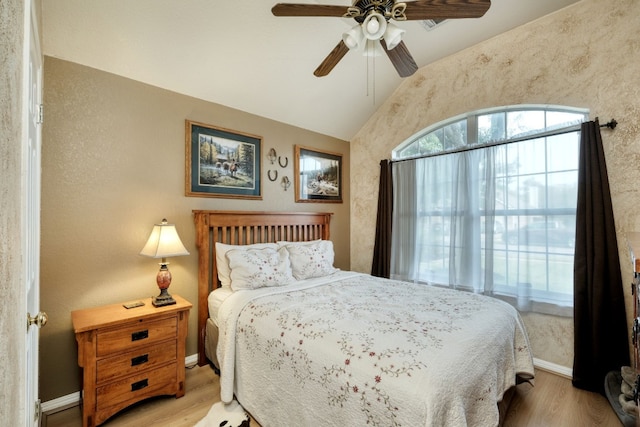 bedroom featuring ceiling fan, light wood-type flooring, and vaulted ceiling