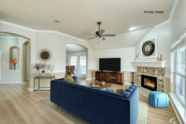 living room with a fireplace, light wood-type flooring, and crown molding