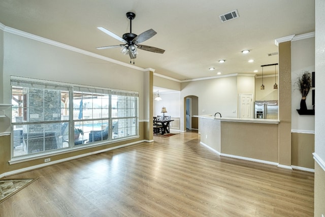 unfurnished living room with ceiling fan, light hardwood / wood-style floors, and ornamental molding