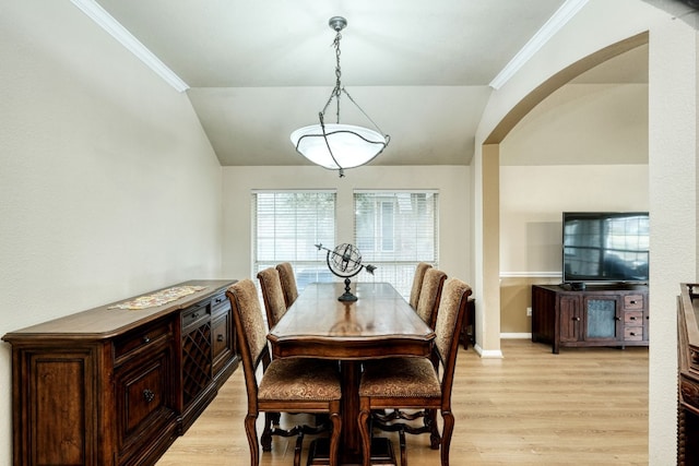 dining area featuring lofted ceiling, light wood-type flooring, and crown molding