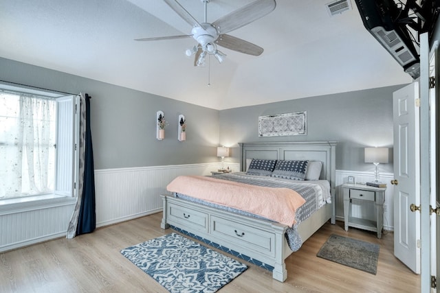 bedroom featuring multiple windows, ceiling fan, light hardwood / wood-style flooring, and lofted ceiling