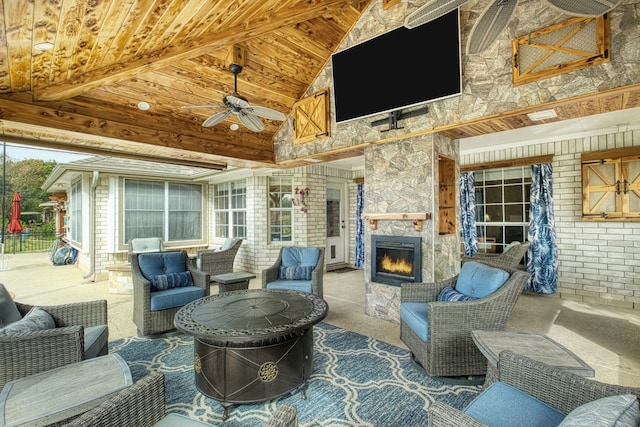 view of patio with an outdoor stone fireplace and ceiling fan