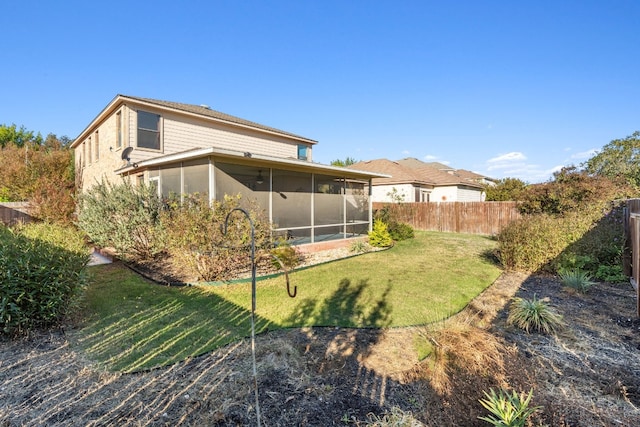 back of house featuring a sunroom and a lawn