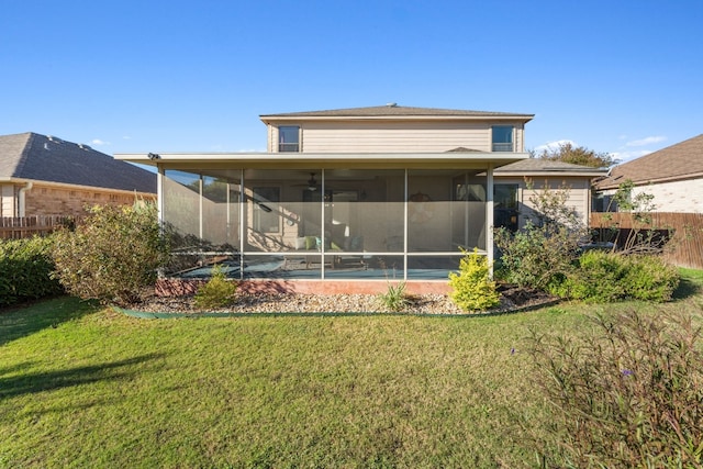 rear view of house featuring a yard and a sunroom