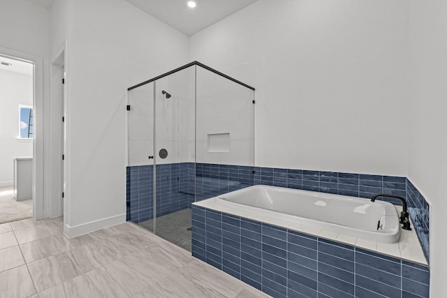 5900 Comanche Moon Trl, Austin, TX 78747 - full bathroom featuring a garden tub, a shower stall, and baseboards