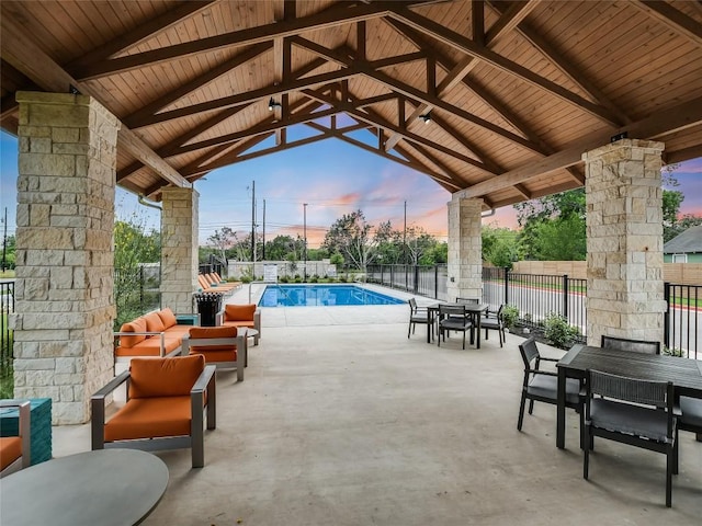 patio terrace at dusk with a gazebo and a fenced in pool