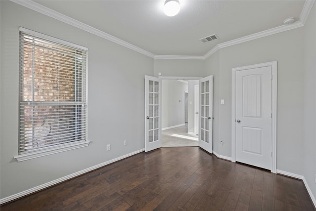 empty room featuring dark hardwood / wood-style flooring, crown molding, and french doors