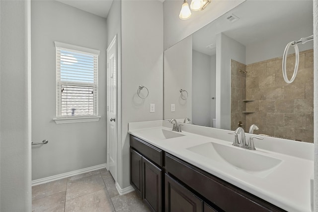 bathroom with a tile shower and vanity