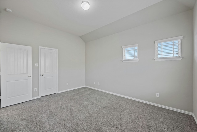 carpeted empty room featuring lofted ceiling