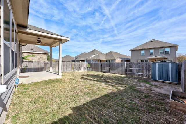 view of yard featuring ceiling fan, a patio area, and a storage shed