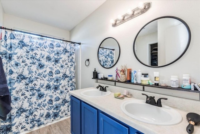 bathroom featuring hardwood / wood-style flooring, vanity, and walk in shower