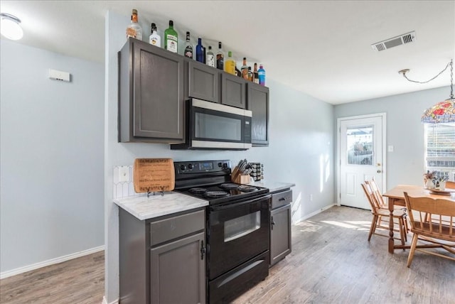 kitchen featuring light stone countertops, black range with electric cooktop, and light hardwood / wood-style floors