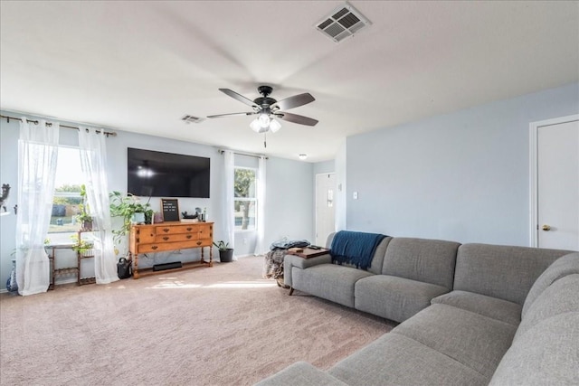 living room with light colored carpet, a wealth of natural light, and ceiling fan