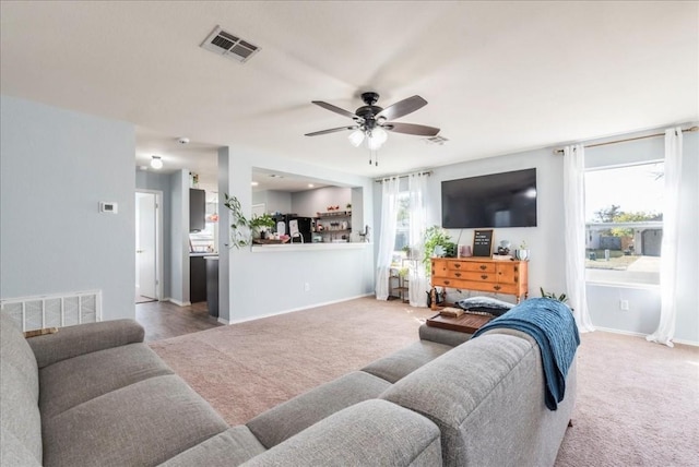 carpeted living room featuring ceiling fan and a healthy amount of sunlight