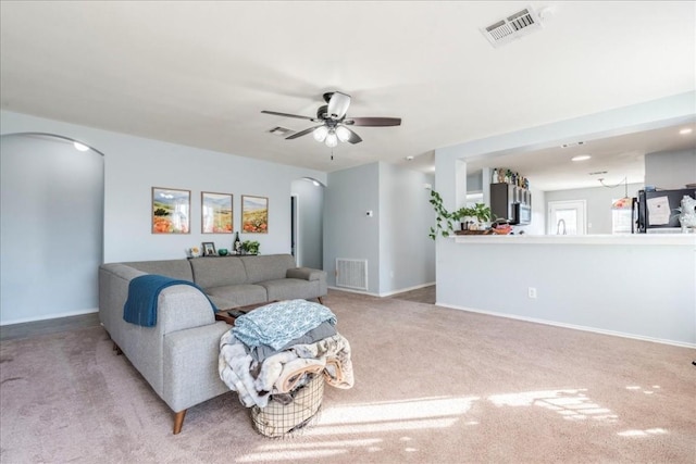 living room with ceiling fan and light colored carpet