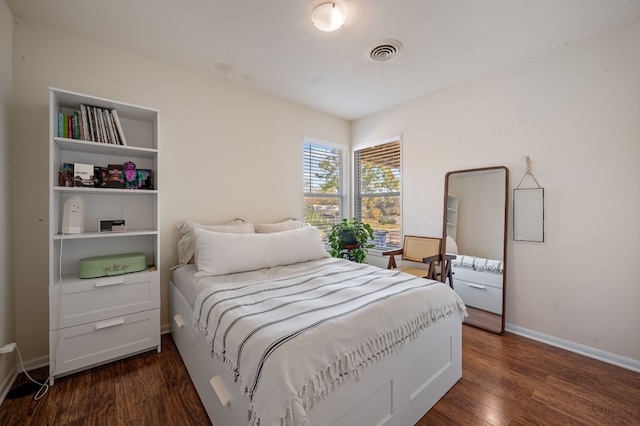 bedroom with dark hardwood / wood-style floors