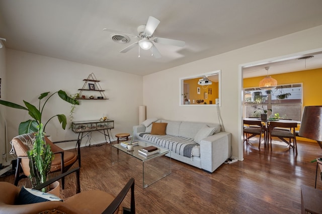 living room featuring dark hardwood / wood-style flooring and ceiling fan