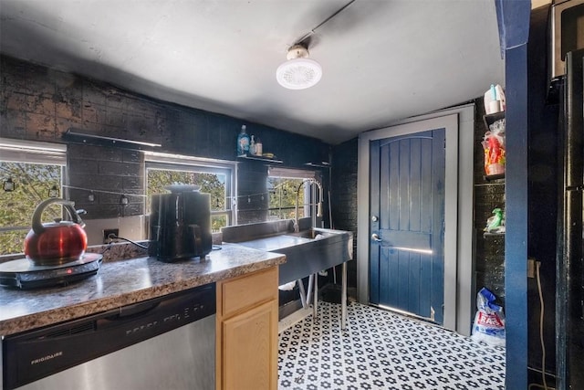 kitchen with light brown cabinetry and stainless steel dishwasher