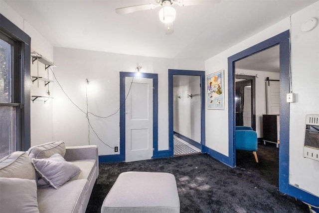 living room with a barn door, ceiling fan, and dark carpet