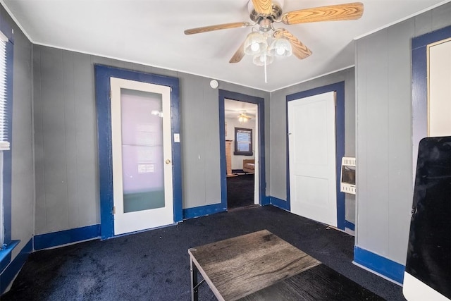 carpeted entrance foyer featuring ceiling fan and heating unit