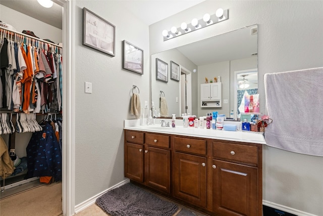 3204 Barksdale Dr, Austin, TX 78725 - bathroom with vanity, a walk in closet, and baseboards