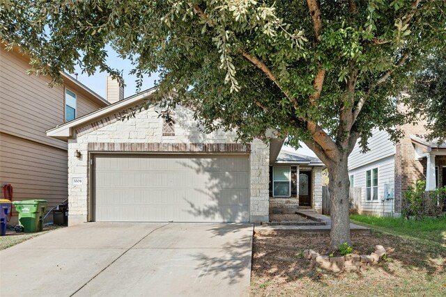 3204 Barksdale Dr, Austin, TX 78725 - view of front of home with stone siding, a chimney, driveway, and an attached garage