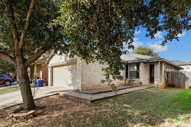 3204 Barksdale Dr, Austin, TX 78725 - view of front facade featuring concrete driveway, stone siding, and an attached garage