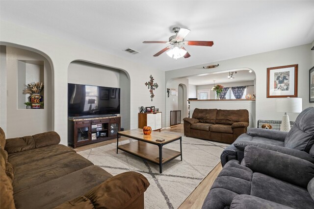 3204 Barksdale Dr, Austin, TX 78725 - living room featuring a ceiling fan, arched walkways, and light wood-type flooring