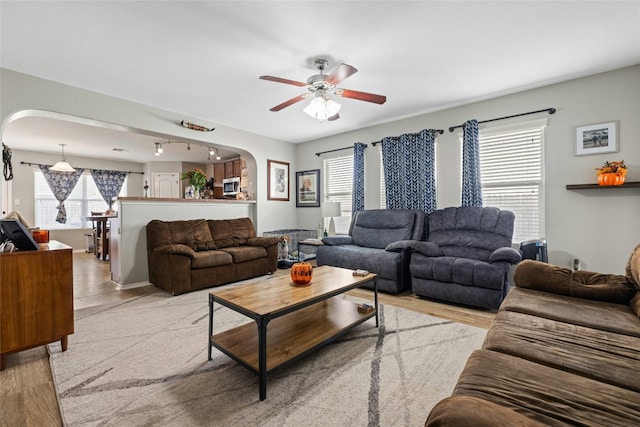 3204 Barksdale Dr, Austin, TX 78725 - living area with arched walkways, a ceiling fan, and wood finished floors