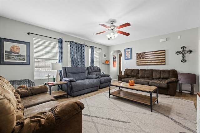 3204 Barksdale Dr, Austin, TX 78725 - living room featuring arched walkways, a ceiling fan, wood finished floors, and baseboards