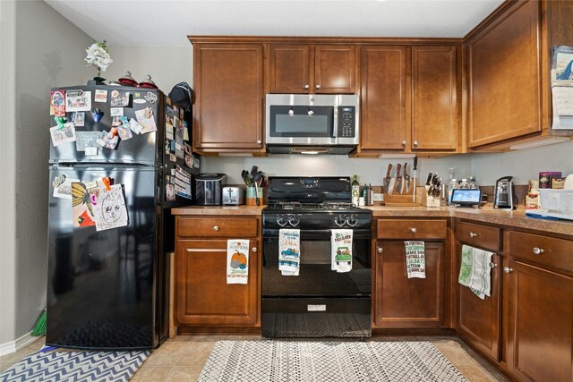 3204 Barksdale Dr, Austin, TX 78725 - kitchen featuring black appliances, light countertops, and light tile patterned floors