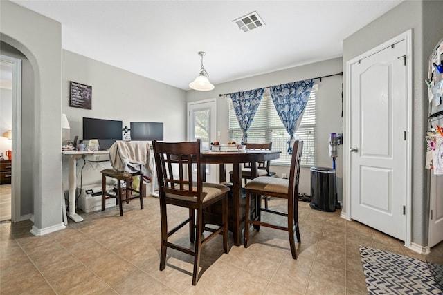 3204 Barksdale Dr, Austin, TX 78725 - dining area featuring baseboards, arched walkways, and light tile patterned flooring