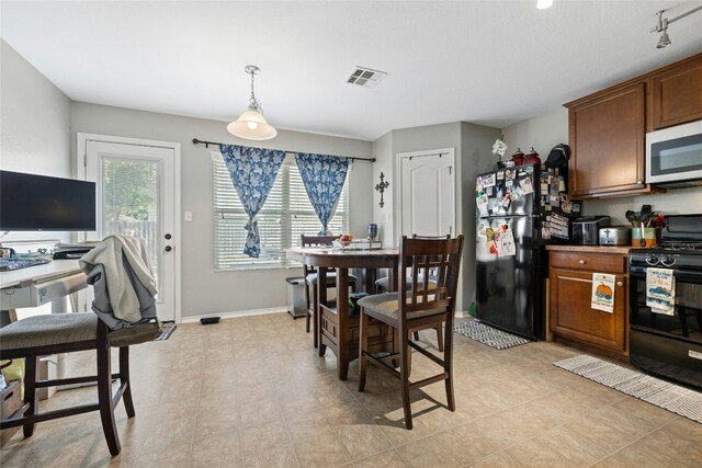 3204 Barksdale Dr, Austin, TX 78725 - kitchen featuring black appliances, baseboards, brown cabinets, and pendant lighting