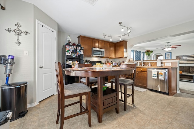 kitchen with kitchen peninsula, appliances with stainless steel finishes, and ceiling fan