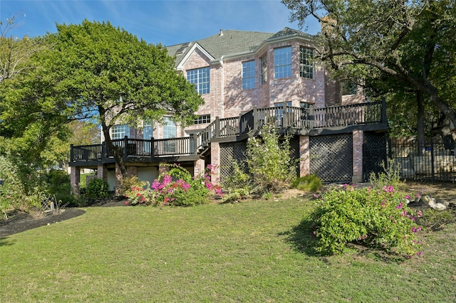 view of front of house with a front yard, stairway, fence, a deck, and brick siding