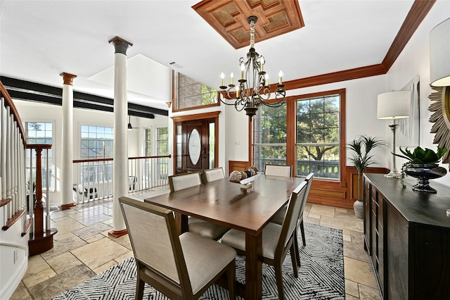 dining space with ornate columns, ornamental molding, and an inviting chandelier