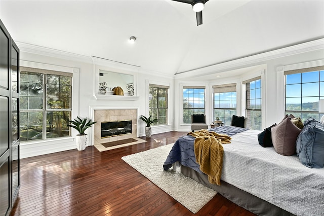 bedroom featuring multiple windows, wood-type flooring, lofted ceiling, and a fireplace