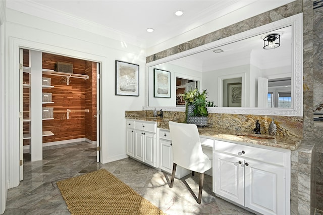 bathroom with baseboards, double vanity, recessed lighting, a sink, and crown molding