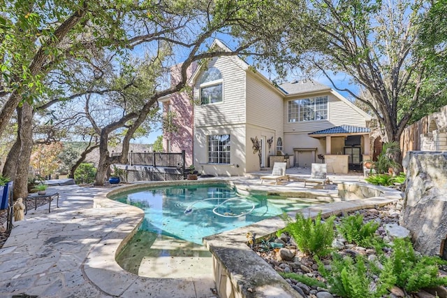 outdoor pool featuring a patio area, a wooden deck, and fence