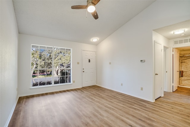 unfurnished room featuring a textured ceiling, ceiling fan, light hardwood / wood-style flooring, and vaulted ceiling