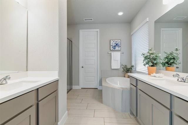 bathroom with shower with separate bathtub and vanity