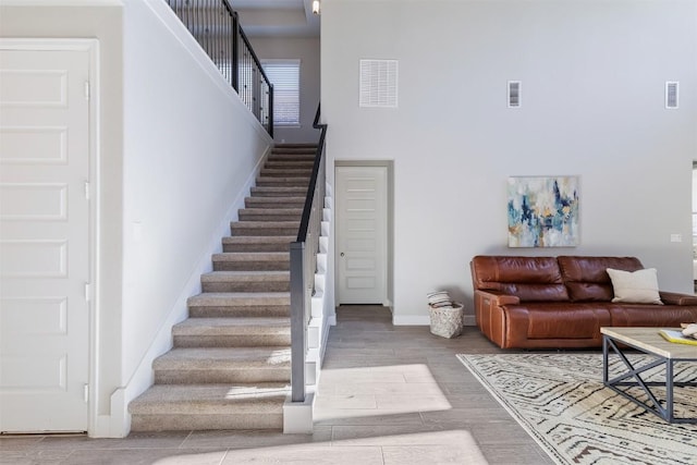 interior space featuring a towering ceiling and hardwood / wood-style flooring