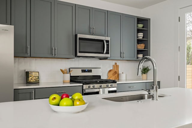 5107 Menchaca Rd Unit 4, Austin, TX 78745 - kitchen featuring appliances with stainless steel finishes, light countertops, decorative backsplash, open shelves, and gray cabinets