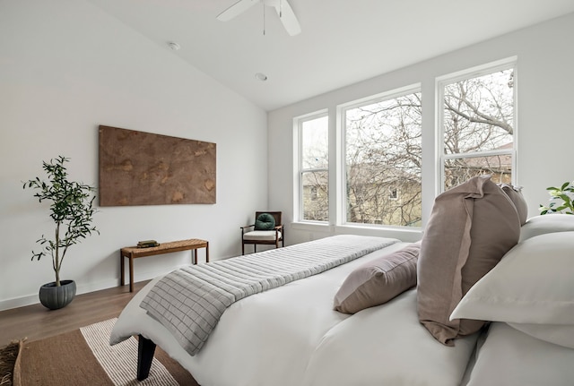 bedroom with ceiling fan, lofted ceiling, multiple windows, and hardwood / wood-style floors