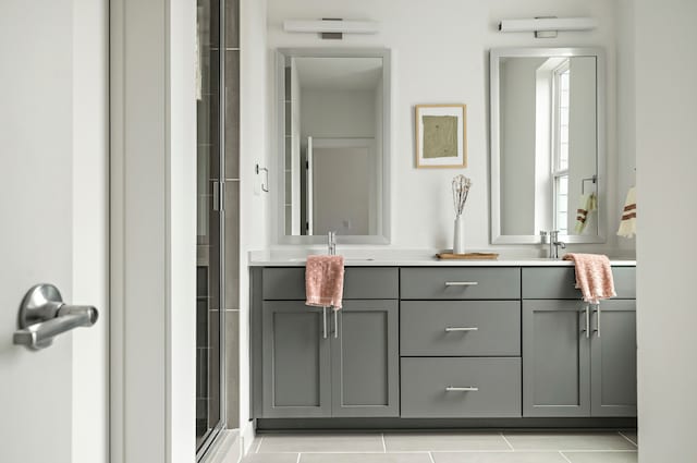 bathroom with walk in shower, vanity, and tile patterned flooring