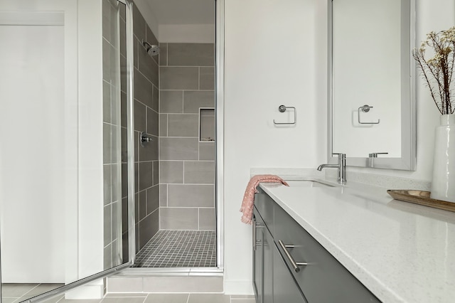 bathroom featuring a shower with shower door, tile patterned floors, and vanity