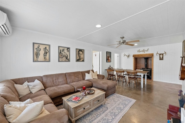 living room featuring a wall mounted air conditioner, ceiling fan, concrete flooring, and a wood stove