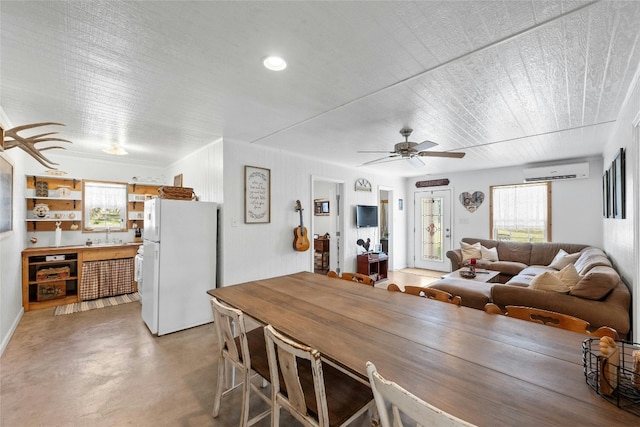 dining area featuring ceiling fan and a wall mounted AC