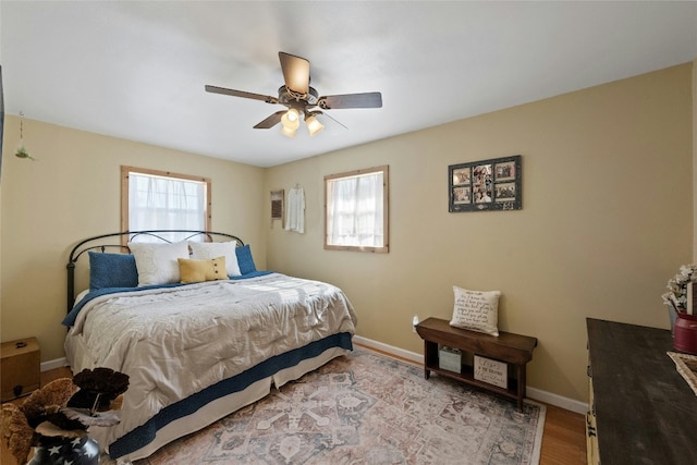 bedroom featuring multiple windows, ceiling fan, and light hardwood / wood-style floors