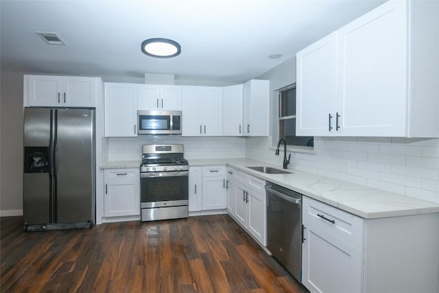 kitchen featuring backsplash, dark wood-type flooring, sink, white cabinetry, and stainless steel appliances